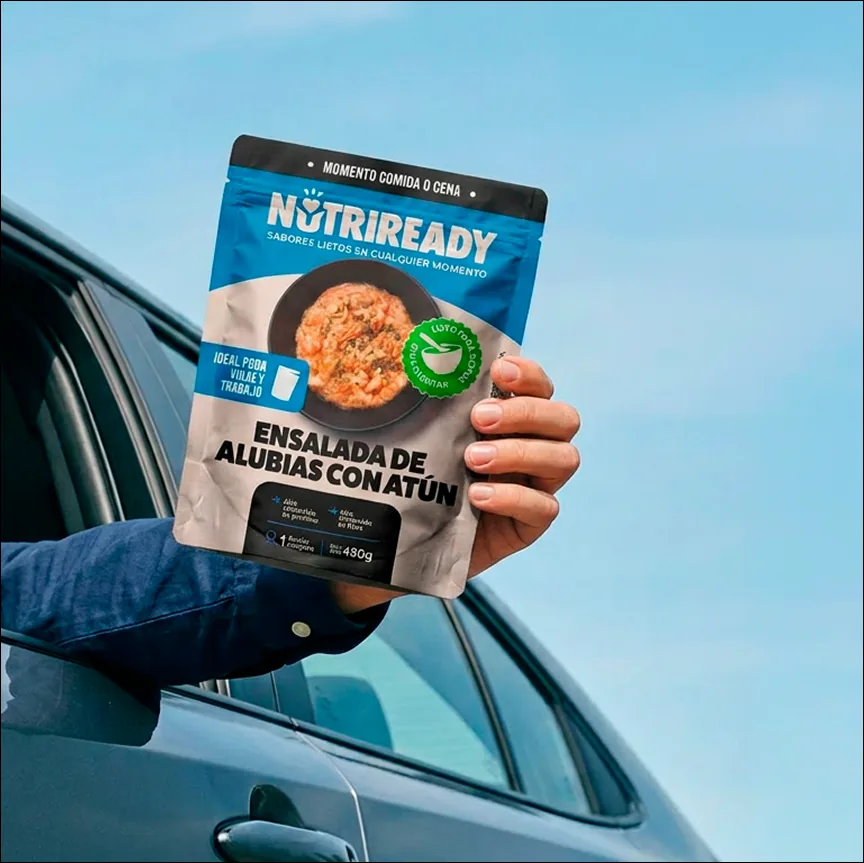 Persona mostrando un plato Nutriready por la ventanilla del coche